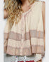 Woman wearing a sleeveless top with intricate patterns on a white background