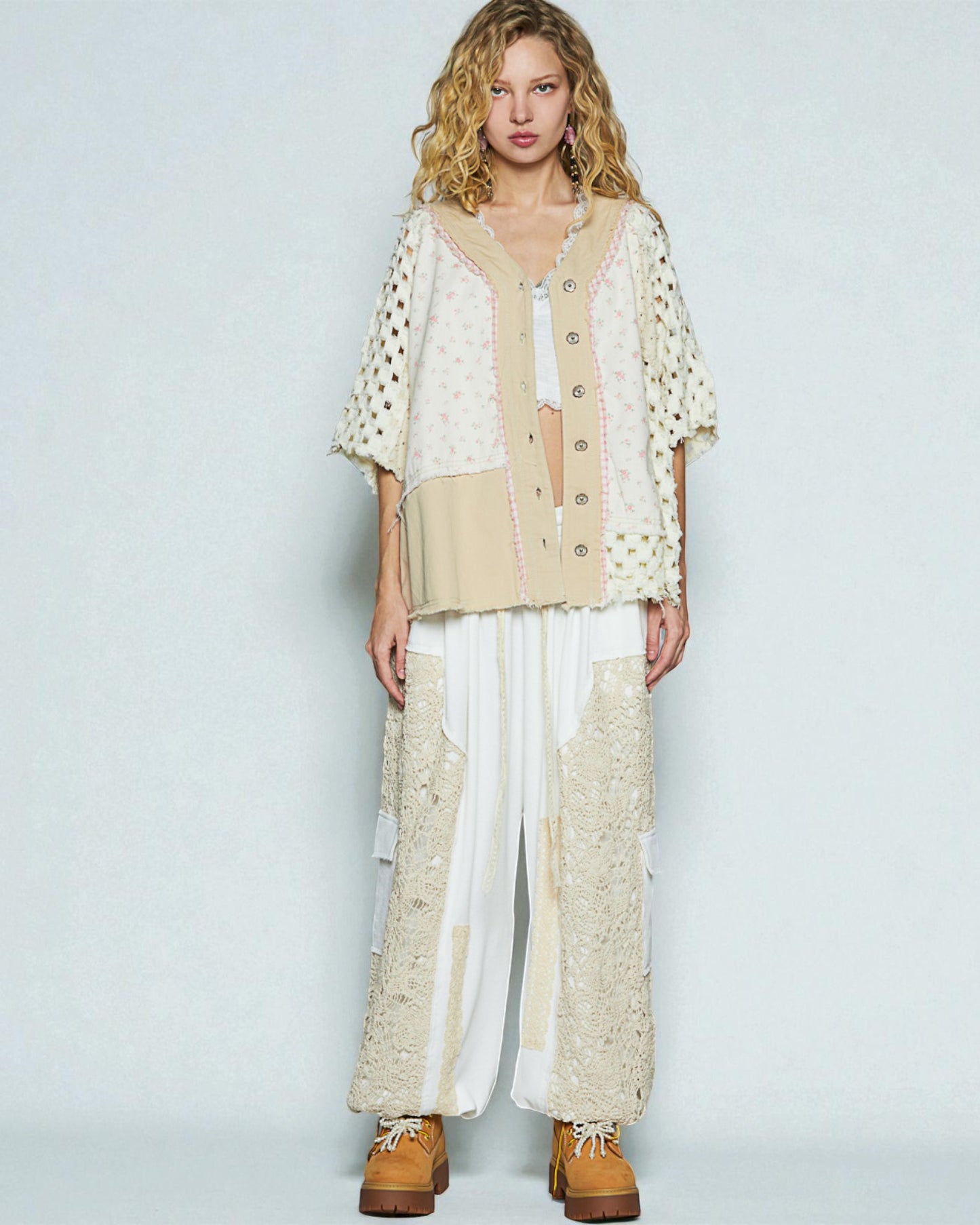 Woman wearing a beige and white outfit with a plain background