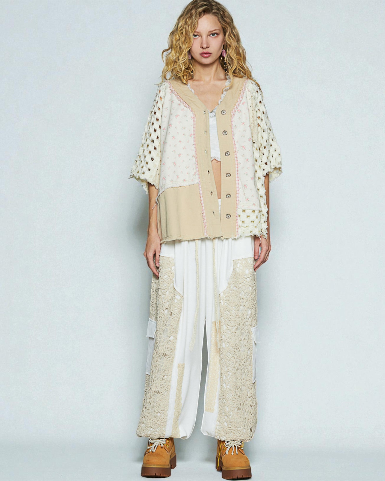 Woman wearing a beige and white outfit with a plain background