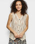 Woman wearing a beige knitted vest on a plain background
