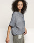 Woman wearing a gray textured blouse against a plain background