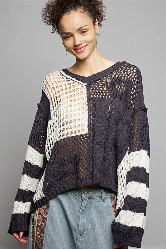 Woman wearing a black and white patterned sweater against a gray background