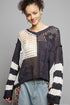 Woman wearing a black and white patterned sweater against a gray background
