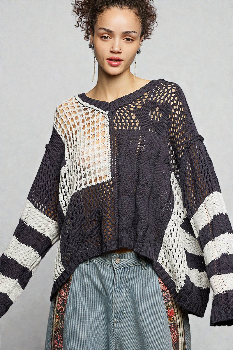 Woman wearing a black and white patterned sweater against a gray background