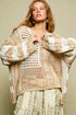 Woman wearing a beige and white knitted cardigan against a beige background