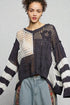 Woman wearing a black and white patterned sweater against a gray background