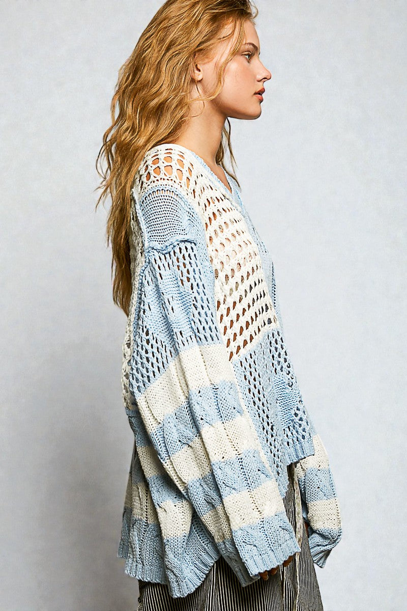 Woman wearing a light blue and white patterned cardigan against a plain background