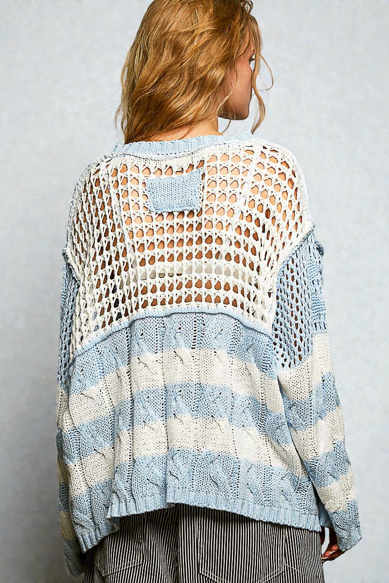 Woman wearing a light blue and white patterned sweater against a plain background