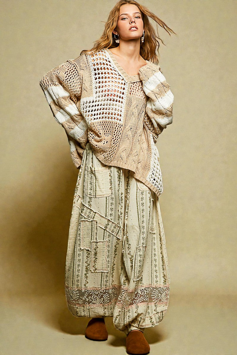 Woman wearing a patterned dress and crochet cardigan against a beige background