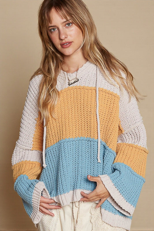 Woman wearing a colorful knit sweater with a beige background