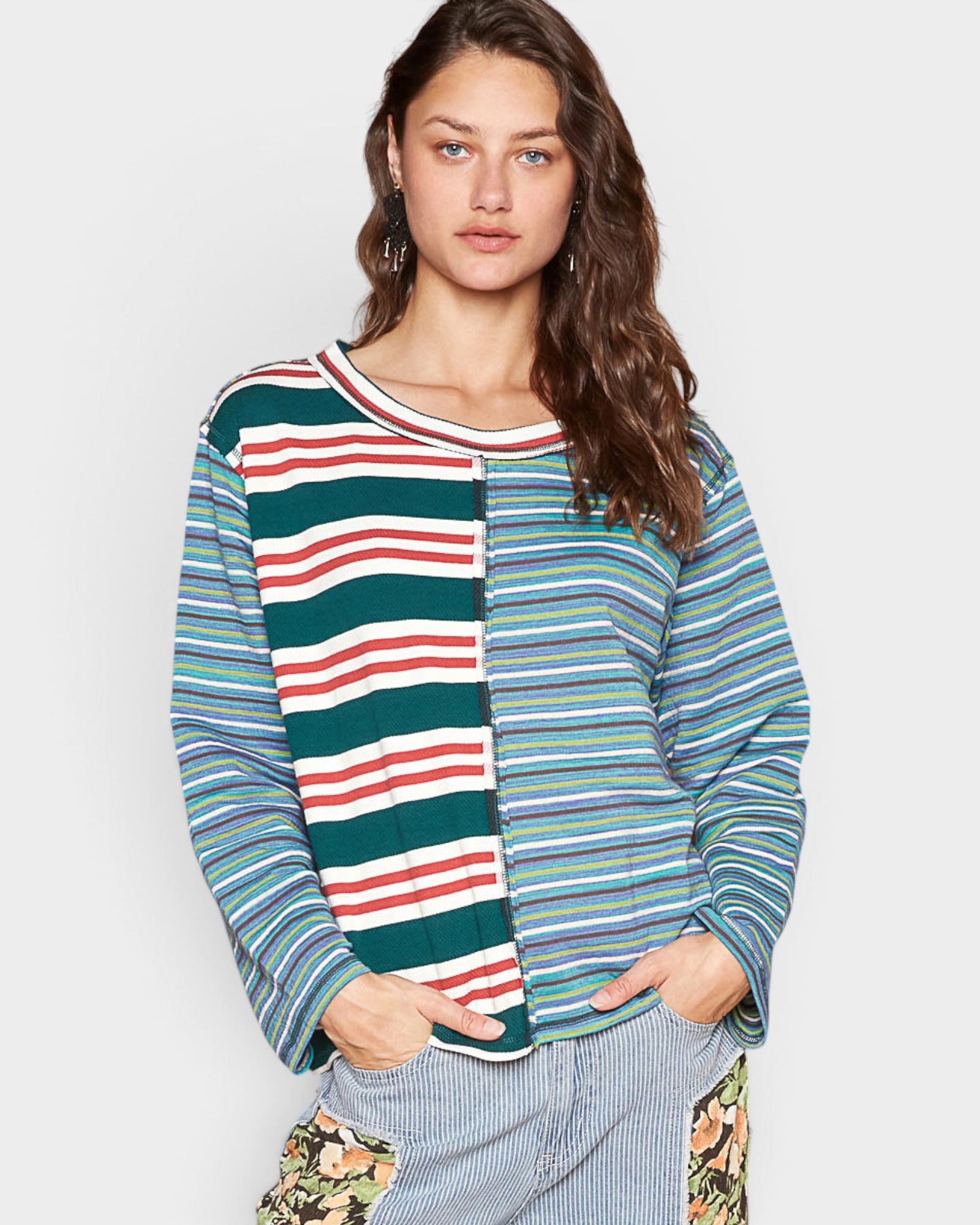 Woman wearing a colorful striped sweater against a plain background