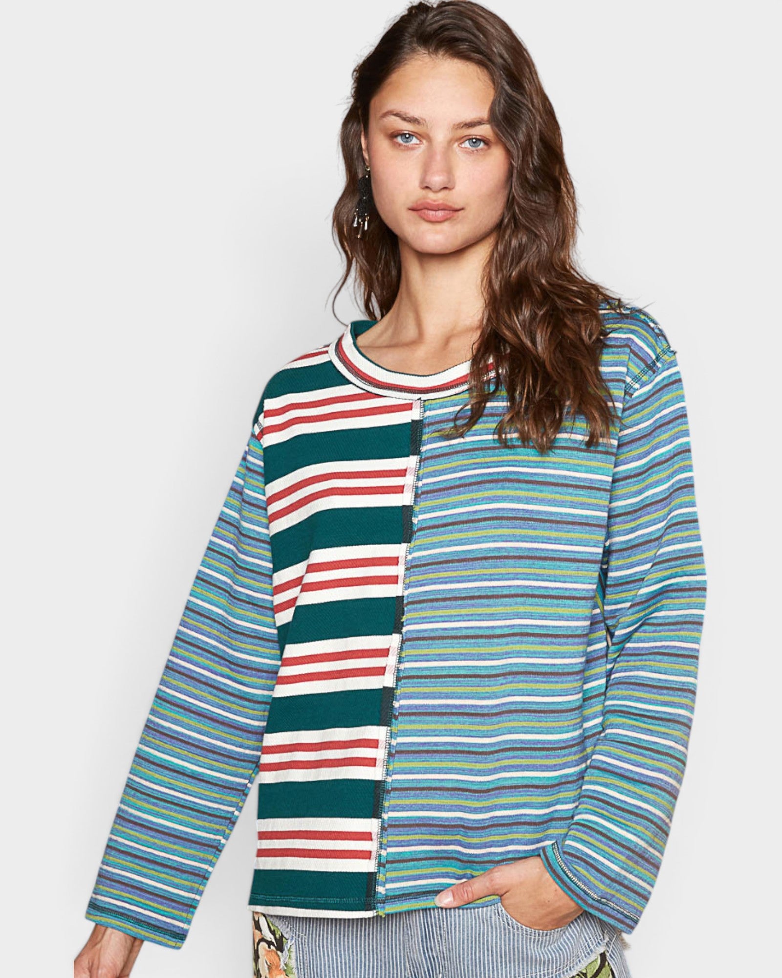 Woman wearing a colorful striped shirt against a plain background