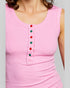Pink sleeveless top with colorful buttons on a gray background
