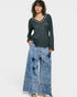 Woman wearing a black long-sleeve top and blue denim pants with star patterns on a white background