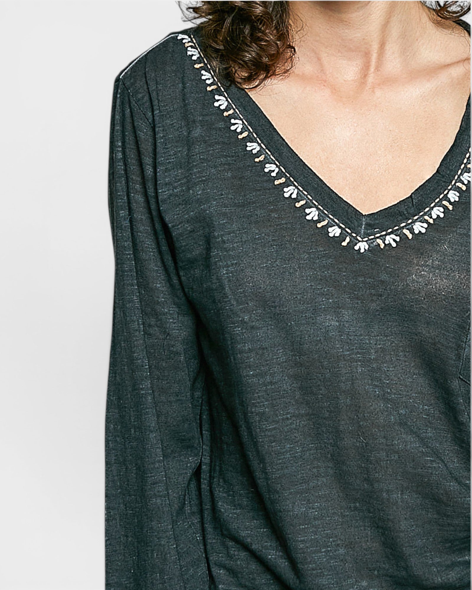 Black long-sleeve top with decorative trim on a plain background