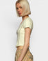 Woman wearing a light-colored top and patterned pants on a plain background