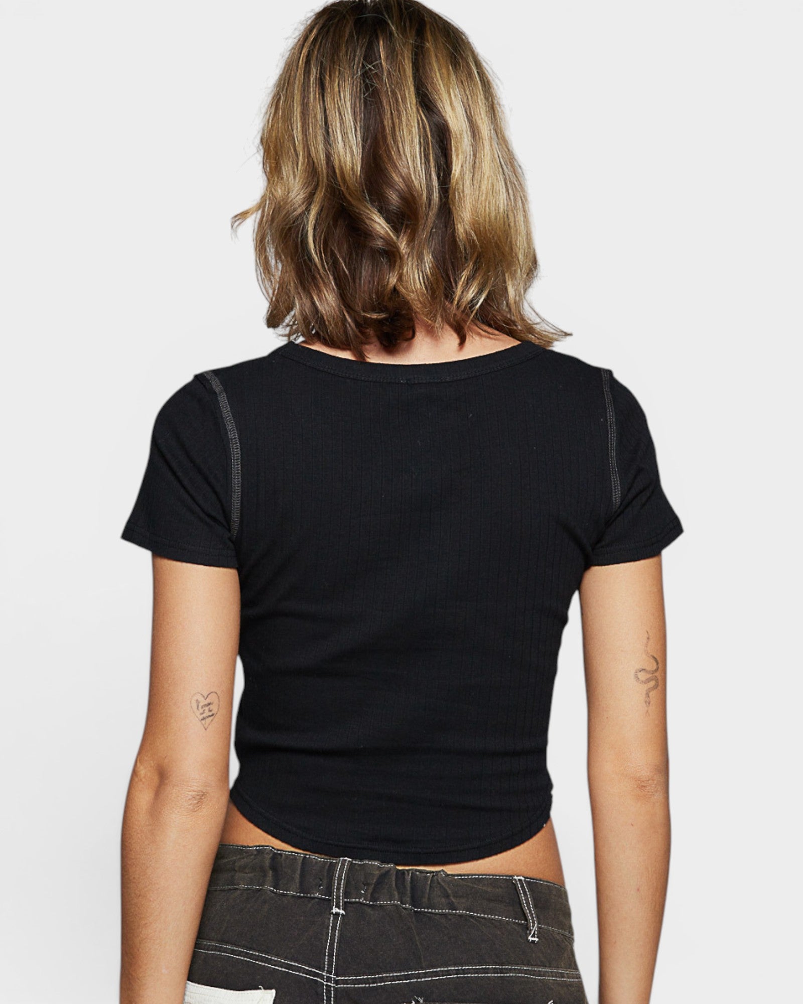 Person wearing a black t-shirt on a plain background