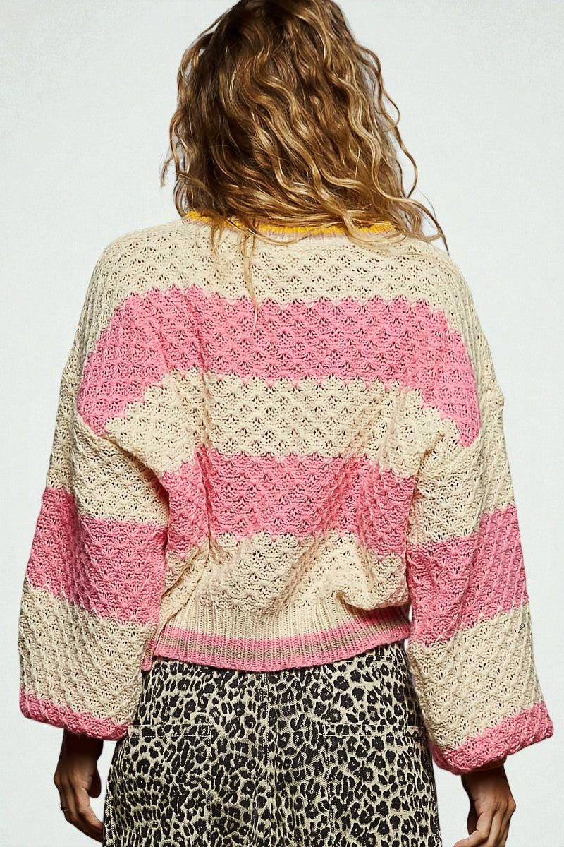 Person wearing a pink and beige striped sweater with a white background