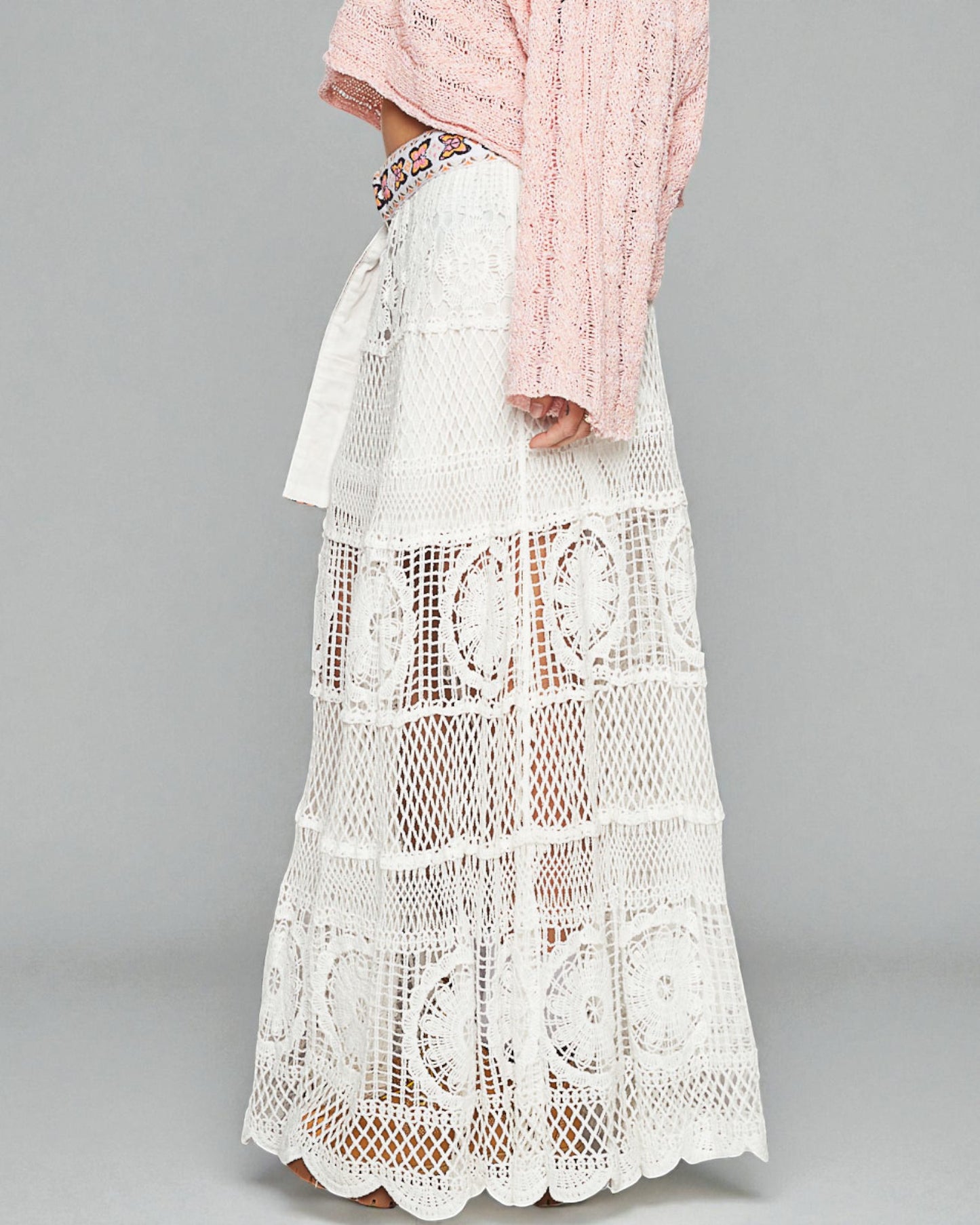 White lace dress with a pink hijab on a gray background