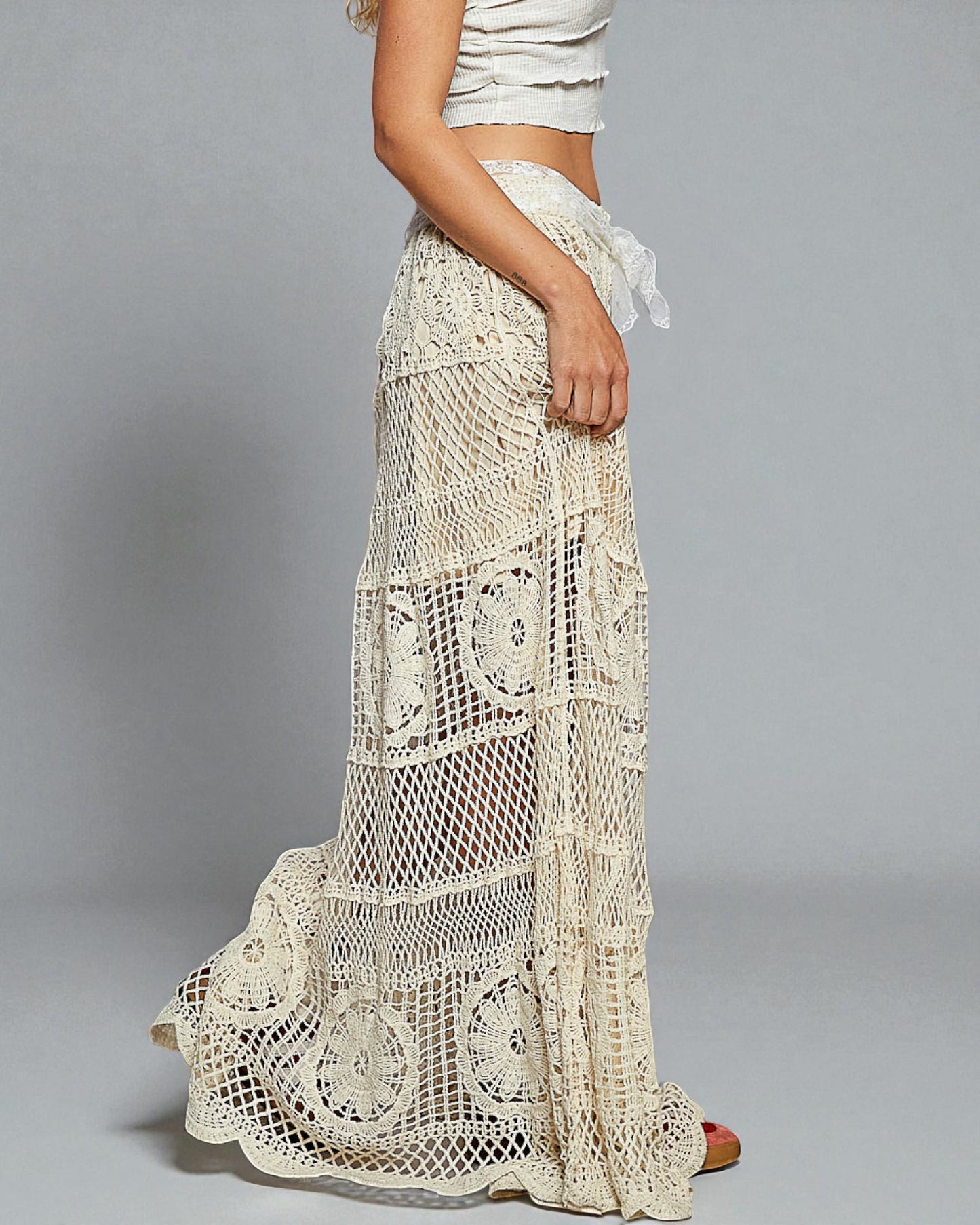 Long crochet skirt worn by a person on a gray background