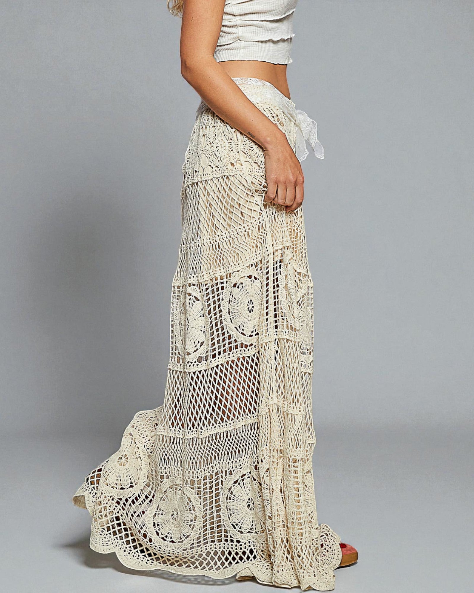 Long crochet skirt worn by a person on a gray background