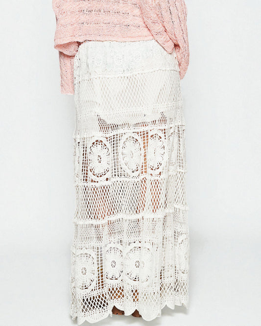 White lace skirt worn by a person on a light gray background