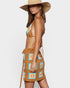 Woman wearing a crochet bikini with a matching skirt on a white background