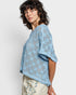 Woman wearing a light blue lace top against a white background