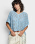 Woman wearing a blue crochet top against a white background