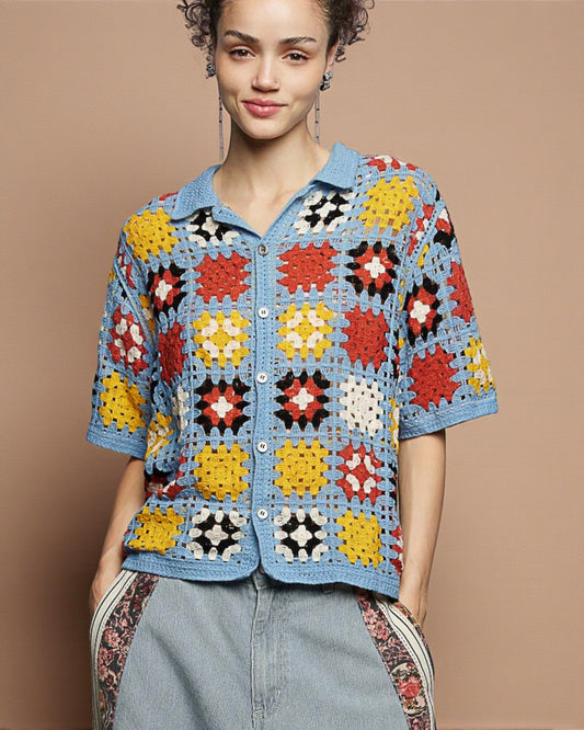 Woman wearing a colorful crochet jacket against a brown background
