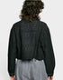 Person wearing a black embroidered blouse and gray pants on a white background
