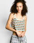 Woman wearing a colorful patterned top against a plain background