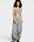 Woman wearing a patterned top and wide-leg pants on a white background