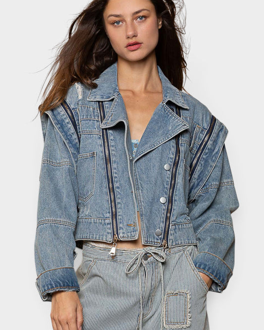 Woman wearing a denim jacket on a plain background