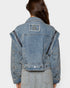 Blue denim jacket with star patch on a white background