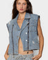 Woman wearing a denim vest on a plain background
