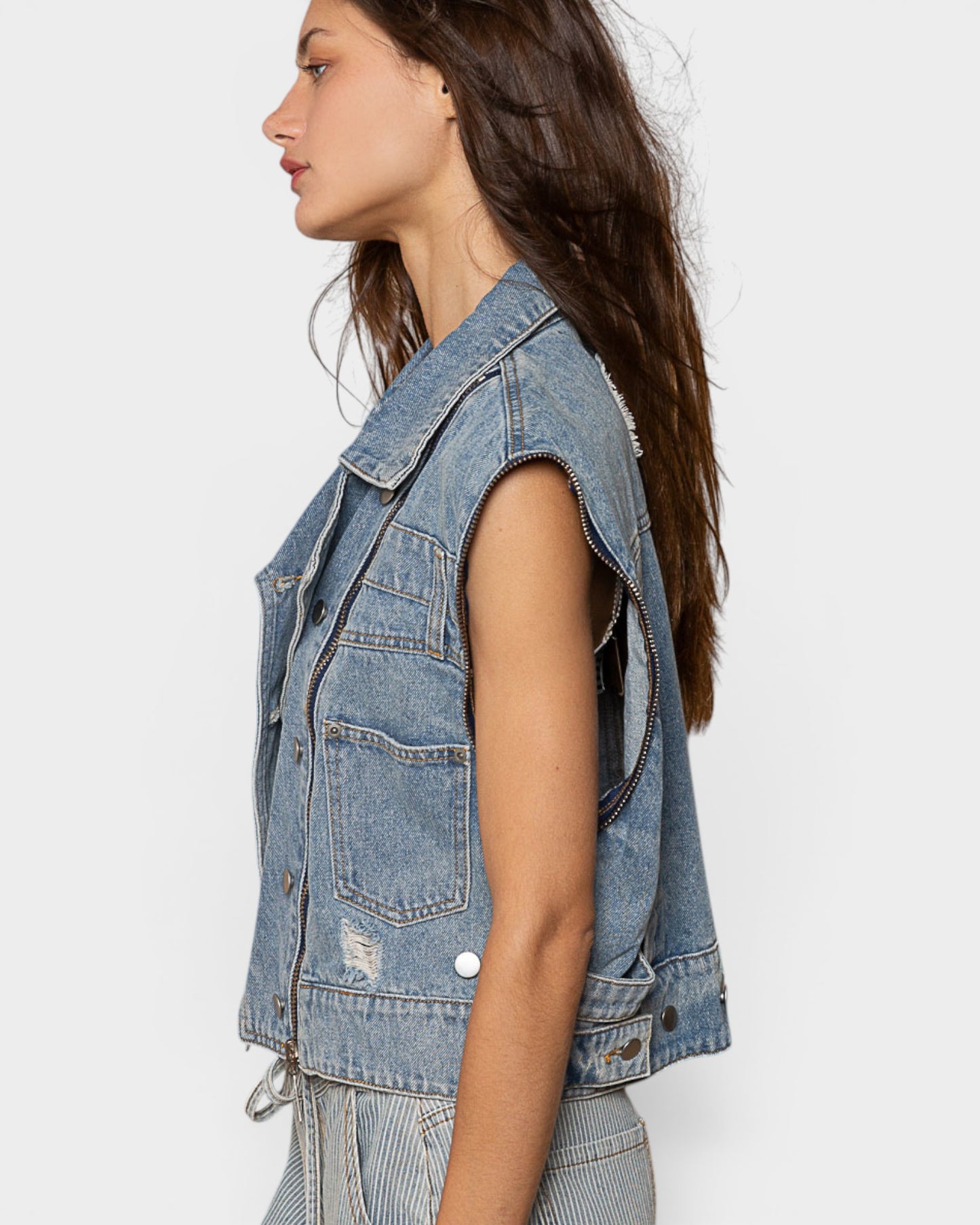 Woman wearing a denim vest on a white background