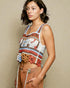 Woman wearing a colorful patterned top against a beige background