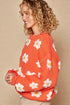 Pull à épaules tombantes et motif marguerites en orange soleil