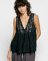 Woman wearing a black lace sleeveless top against a white background