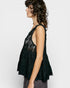 Woman wearing a black lace top against a white background