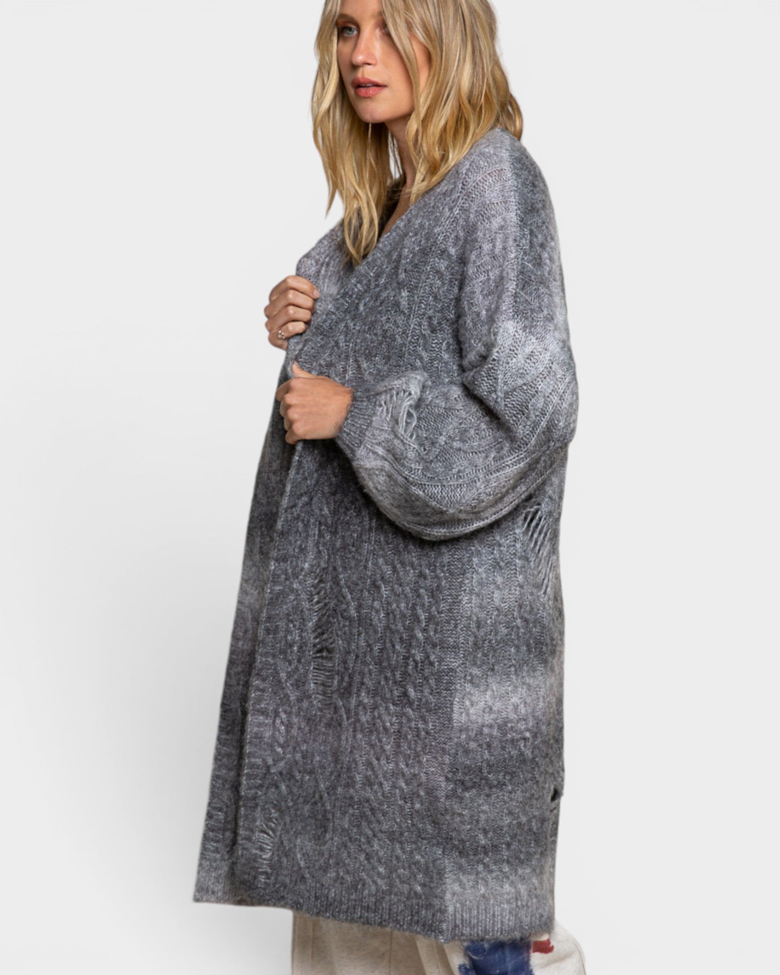Woman wearing a long gray cardigan on a white background