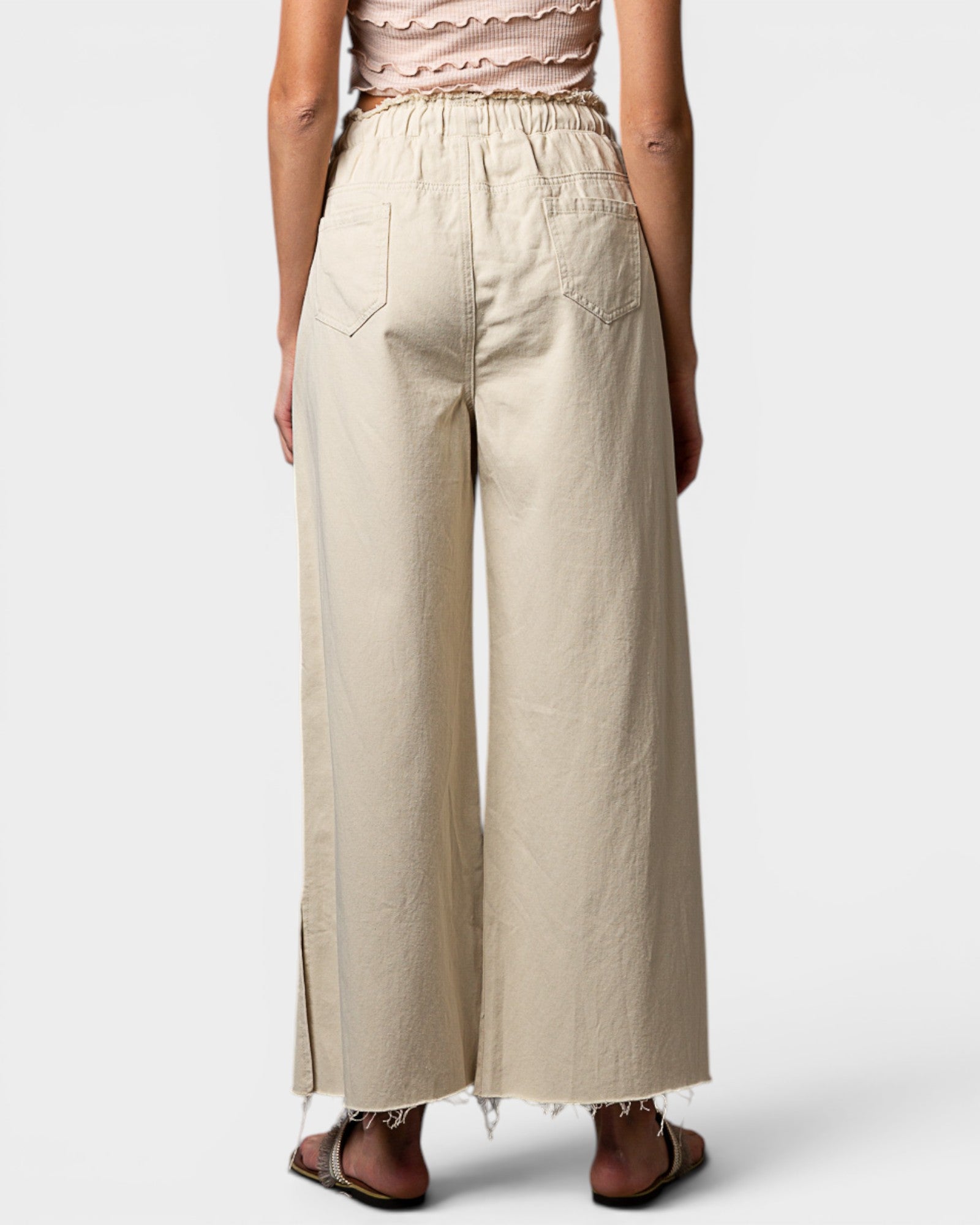 Beige wide-leg pants worn by a person on a white background