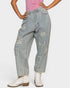Person wearing ripped blue jeans and white boots on a light gray background