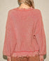 Pink sweater worn by a person against a beige background