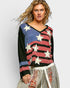 Woman wearing a colorful sweater with star patterns on a plain background