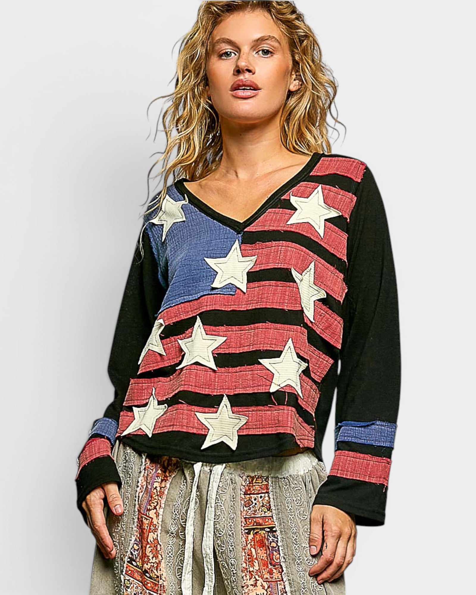 Woman wearing a colorful star-patterned sweater against a white background