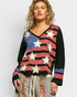 Woman wearing a colorful star-patterned sweater against a white background