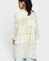 Woman wearing a cream-colored embroidered outfit on a white background