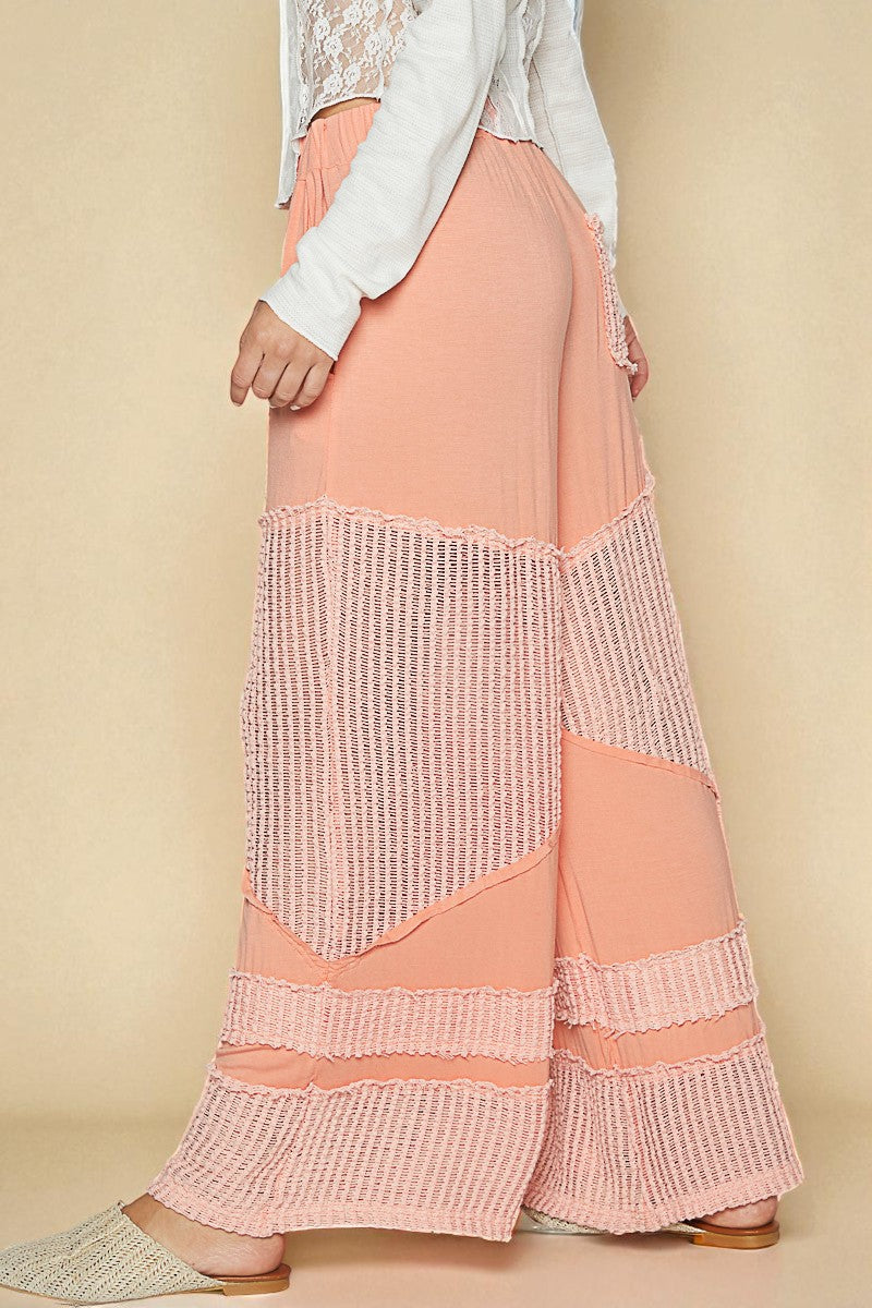 Person wearing a peach skirt with a textured pattern on a beige background